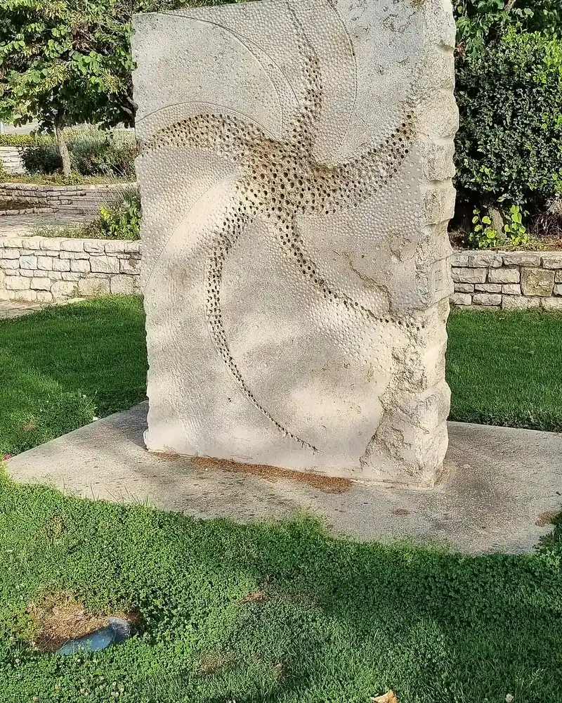 A carved stone sculpture by Bernie Fink on a lawn at Levi and Yitzhak Rabin streets in HaShvatim