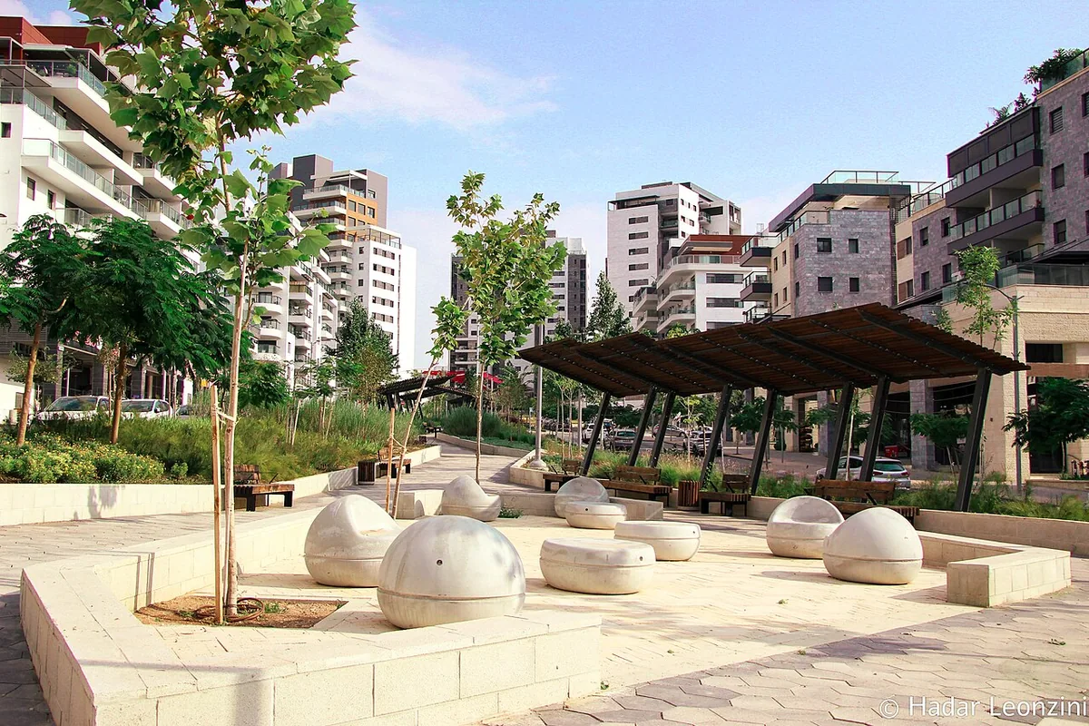 The HaShdera public garden with a pergola and new apartment buildings in Moreshet