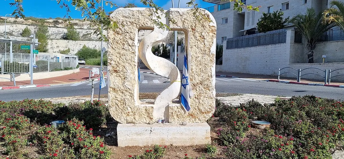 A stone sculpture by Igor Baron beside a street in the Moriah neighbourhood